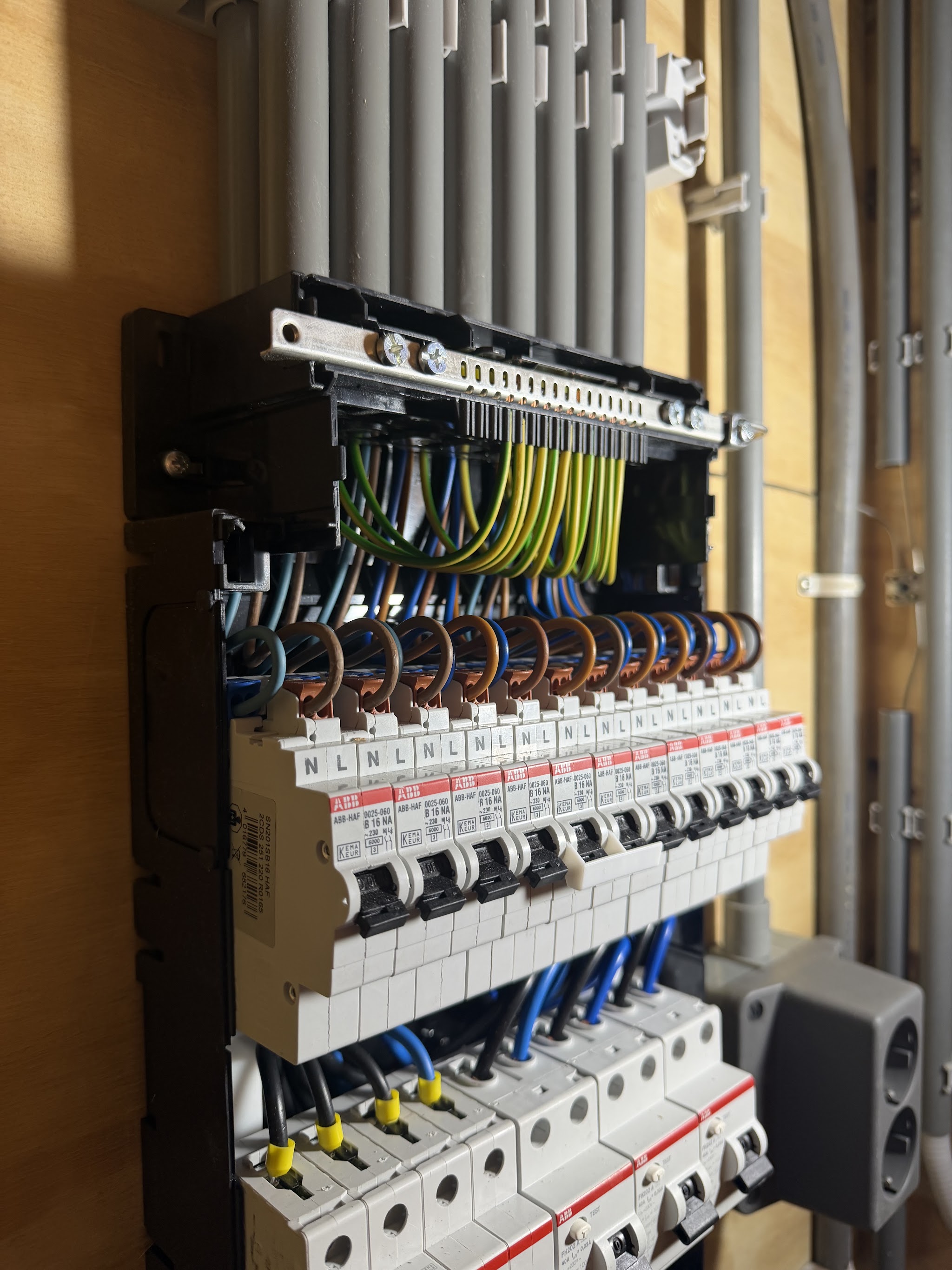 Close-up van een nieuwe groepenkast met ABB automaten, netjes bedraad en met gelabelde N- en L-klemmen